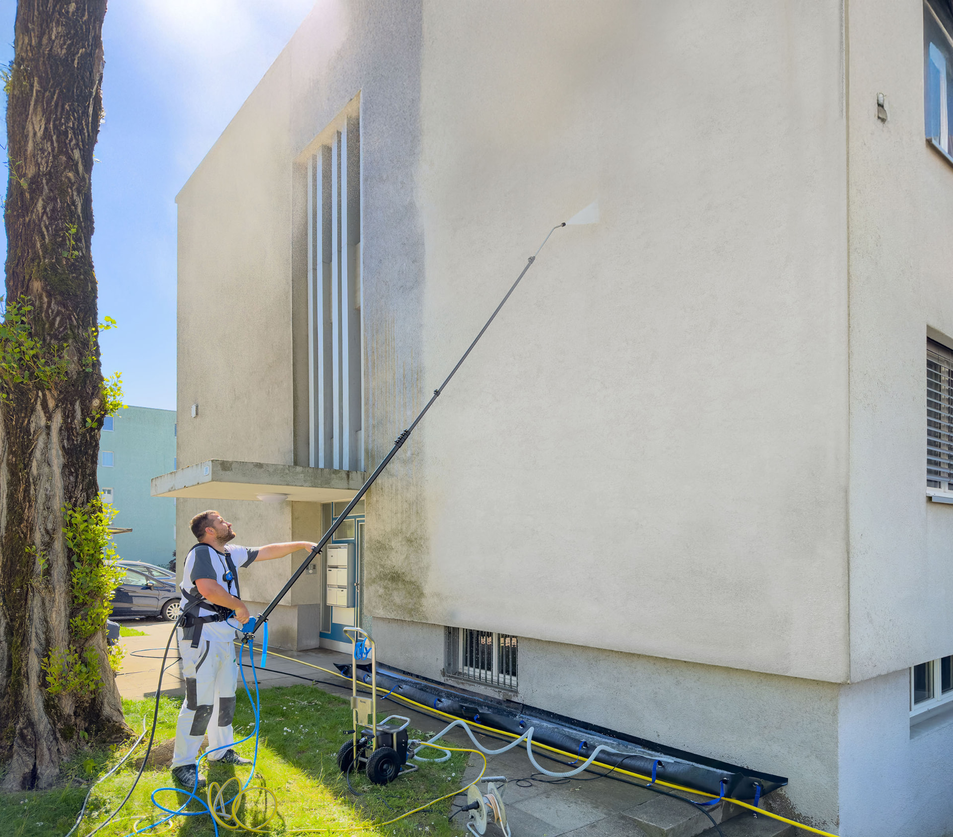 Malermeister Buck reinigt eine Hausfassade mit einer Teleskoplanze